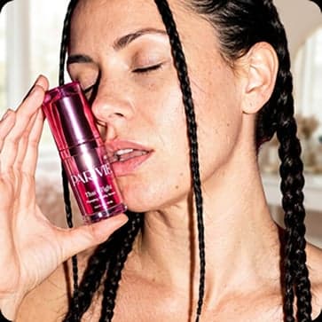 Parivie skincare ad — model holding a serum bottle to her cheek
