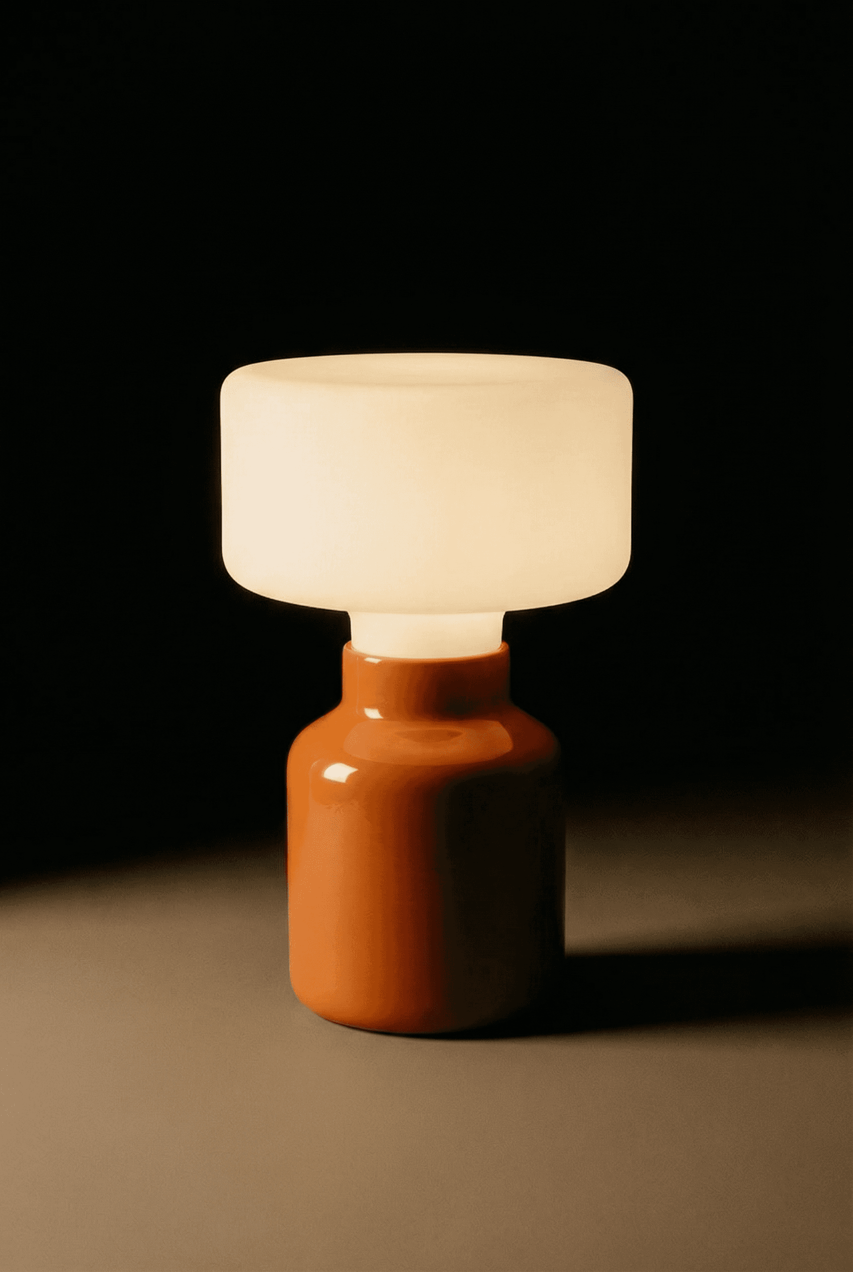 Modern orange ceramic table lamp with frosted glass shade providing warm ambient lighting for contemporary interiors.